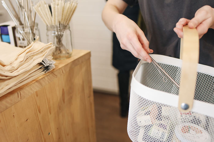 Shopper adding another item to a basket that already holds products, illustrating how to increase average order value without discounts