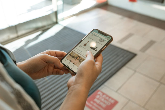 Hands holding a smartphone showing an online shopping app, illustrating zero party data collection for Shopify brands