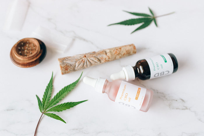 CBD oil dropper bottles and hemp leaves on a marble surface, for CBD brands that can’t run Meta ads