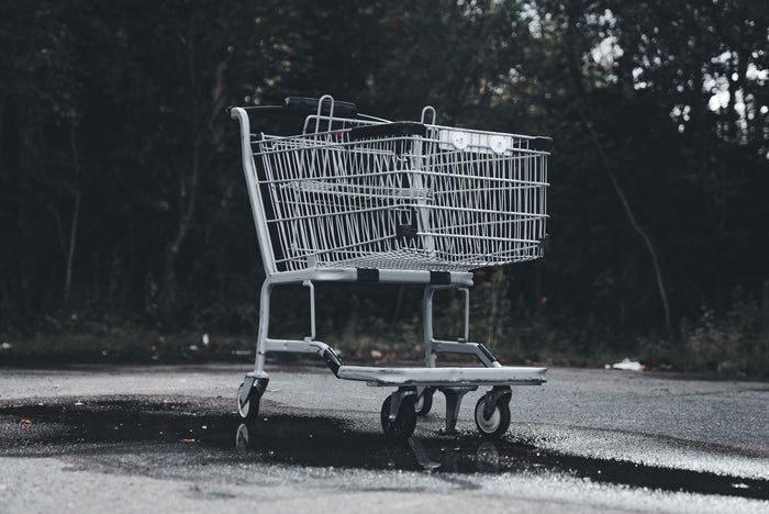 Empty shopping cart left in a deserted parking lot, illustrating abandoned cart recovery without discount codes