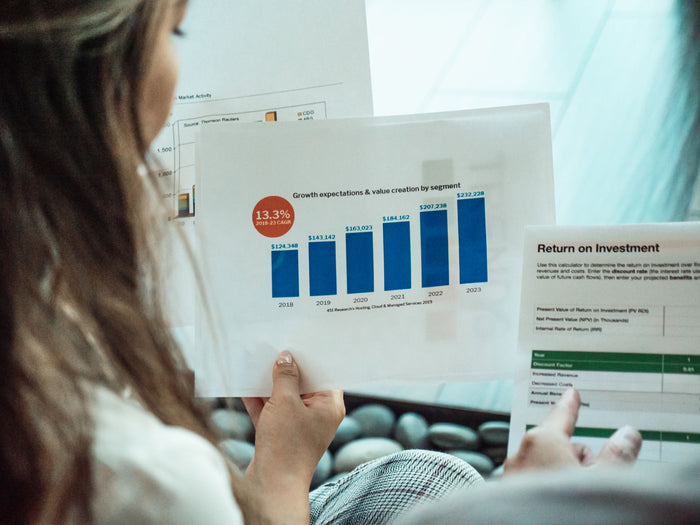 Person reviewing ROI reports and financial graphs to measure gamification platform returns